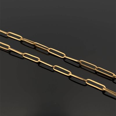 une paire de trombones plaqués or sur un fond noir