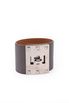 un gros plan sur un bracelet en cuir muni d'une boucle en métal