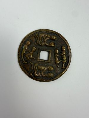 une petite pièce de bronze sur laquelle figurent un homme et une femme