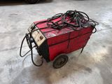 un chariot rouge auquel sont attachés tout un tas de fils