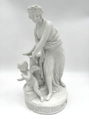 statue d'une femme avec un enfant et un oiseau, posée sur un socle