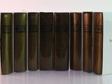 several books are lined up in a row on a white surface