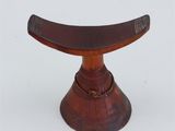 an image of a small wooden stool with a curved top