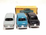 three toy cars sitting next to each other in front of a box
