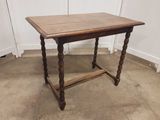 une vieille table en bois avec des pieds tournés et un plateau en bois