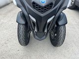 a black motorcycle parked in a parking lot next to a car