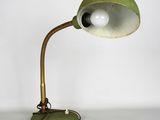 une image représentant une lampe verte posée sur une table, sur fond blanc