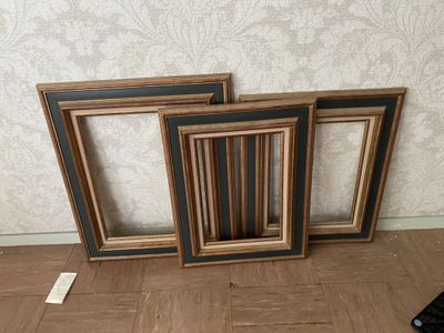 three picture frames sitting on the floor next to each other