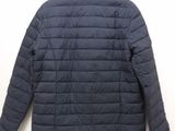 the back of a jacket hanging on a hanger on a wall