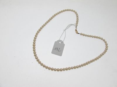 un gros plan d'un collier de perles muni d'une étiquette