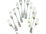 several forks and spoons are arranged in a circle on a white surface
