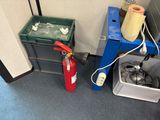 a fire extinguisher next to a trash can in a cubicle