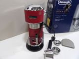 a red coffee maker sitting on a counter next to a box of doughnuts