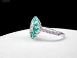 an image of a diamond and emerald ring on a white plate