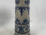 a blue and white vase sitting on a white surface