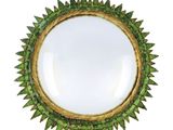 a close up of a mirror on a white background with green leaves