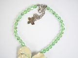 necklace made of green glass beads with a white flower on a silver chain