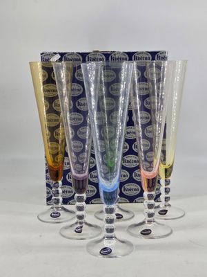 four wine glasses are lined up in a row in front of a box