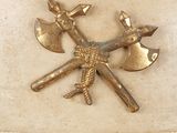 a gold metal object with two axes and a bird on it