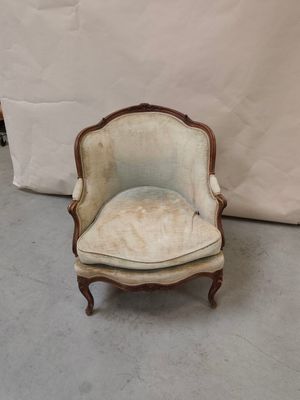une vieille chaise avec une assise rembourrée blanche devant un fond blanc