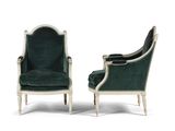 a pair of green velvet chairs with white trim and wood legs
