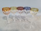 four wine glasses are lined up in a row on a table
