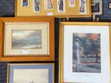 many framed pictures on the wall of a room
