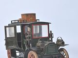 a small model of an old fashioned car on a white surface