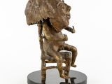 bronze statue of a woman sitting on a chair smoking a cigarette