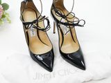black high heel shoes with laces on the toes and a white bag