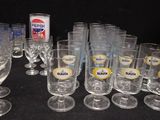 bottles and glasses are lined up on a table with a black background