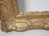 a gold frame with a picture of a man on a bench