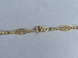 a close up of a gold bracelet on a white surface