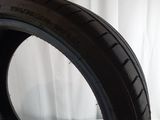 a close up of a tire on a white surface with a curtain in the background