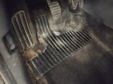 an image of a dirty car floor with a dirty floor mat