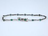 un bracelet orné d'émeraudes et de diamants sur fond blanc