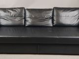 black leather sofa with storage underneath it in a room