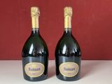 deux bouteilles de champagne posées sur une table l'une à côté de l'autre