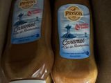 deux bouteilles de condiment sont posées dans une boîte en carton sur une table