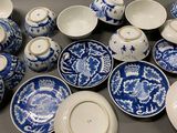 many blue and white plates and bowls on the table
