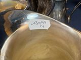 a lot of silver dishes on a table with a price tag on it