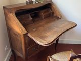a desk with a chair and a lamp in the corner