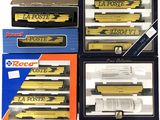 quatre boîtes contenant des wagons jaunes et noirs posées sur une surface blanche