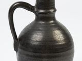 a black vase with a brown handle on a white background