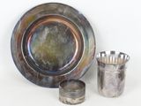 une assiette en argent et une tasse en argent placées l'une à côté de l'autre