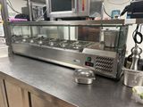 un plan de travail en acier inoxydable sur lequel se trouvent des aliments, dans une cuisine professionnelle