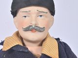a doll of a man with a moustache on his face