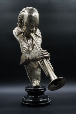 statue en bronze représentant un homme jouant de la trompette sur fond noir