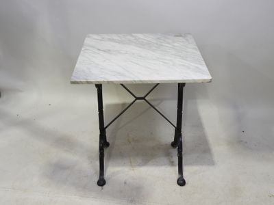 une photo d'une table en marbre avec des pieds en fer et un plateau en marbre blanc
