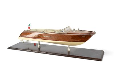 maquette en bois d'un bateau à moteur sur un socle, sur fond blanc